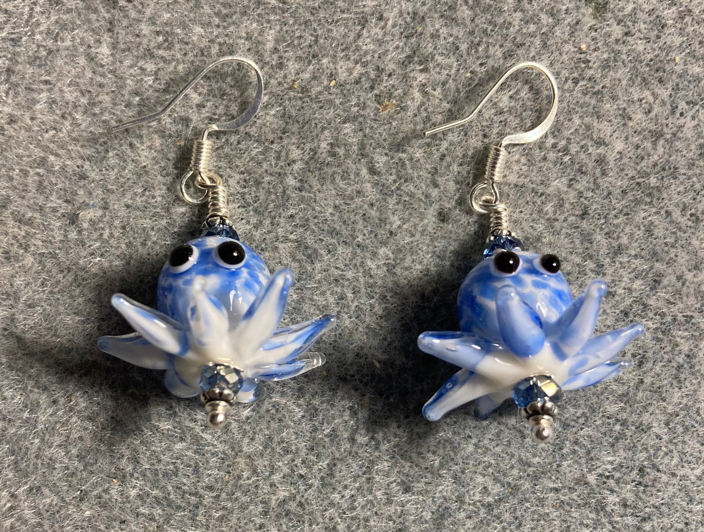 Blue and white mottled lamp work octopus bead earrings adorned with light blue Chinese crystal beads.