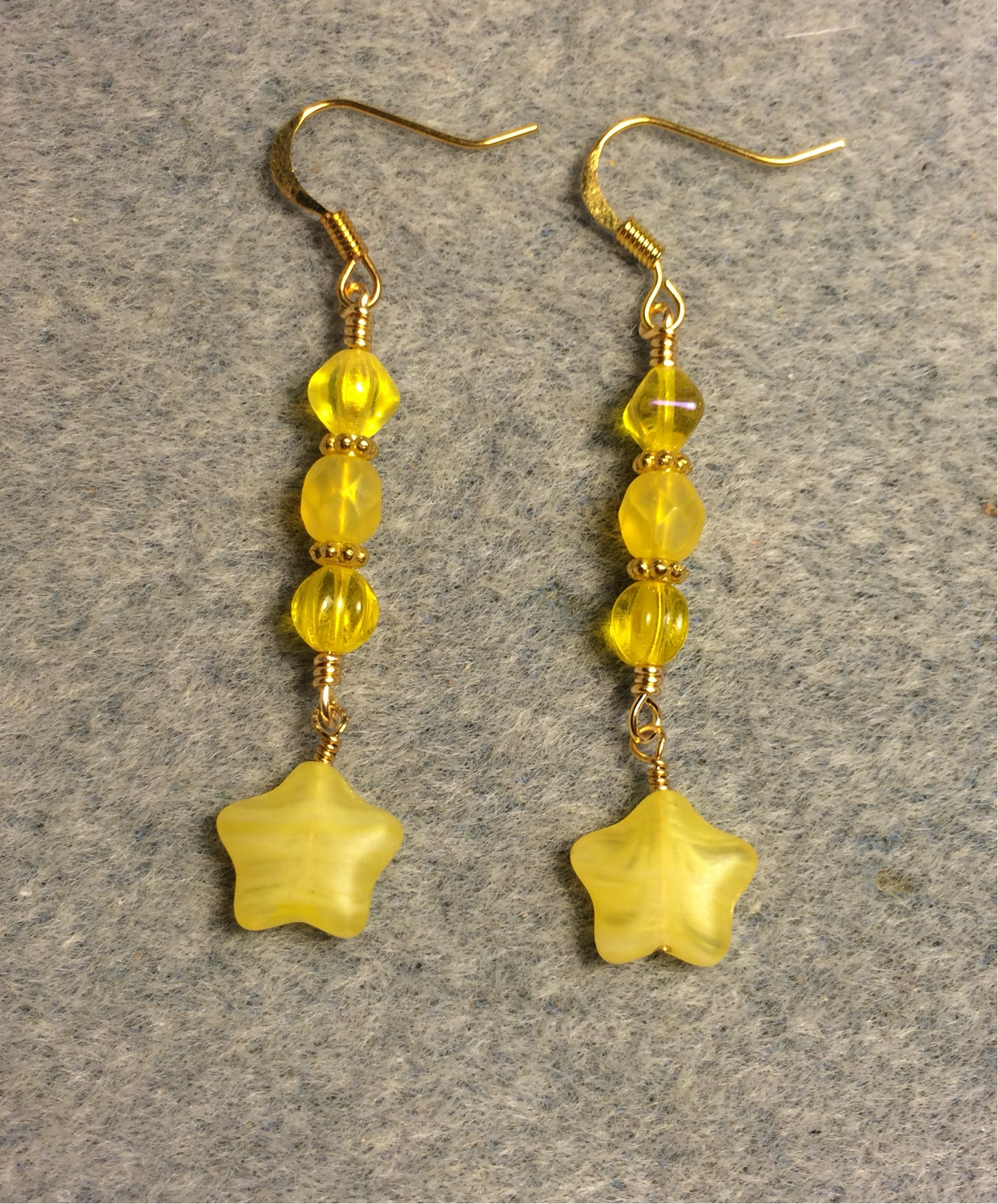 Small opaque yellow Czech glass star bead earrings adorned with yellow Czech glass beads.