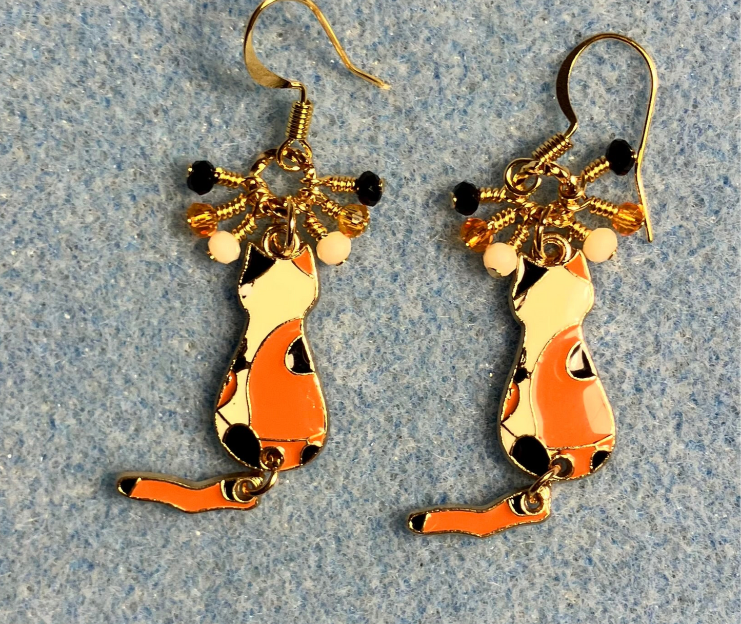 Orange, black, and white enamel calico cat charm earrings adorned with tiny dangling orange, black, and white Chinese crystal beads.