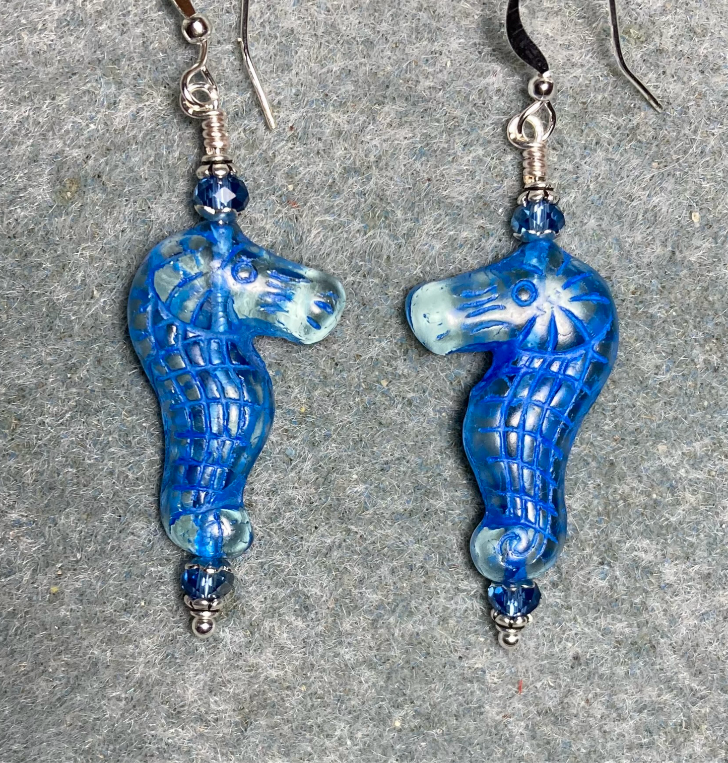 Clear (with blue inlay) Czech glass seahorse bead earrings adorned with blue Chinese crystal beads.