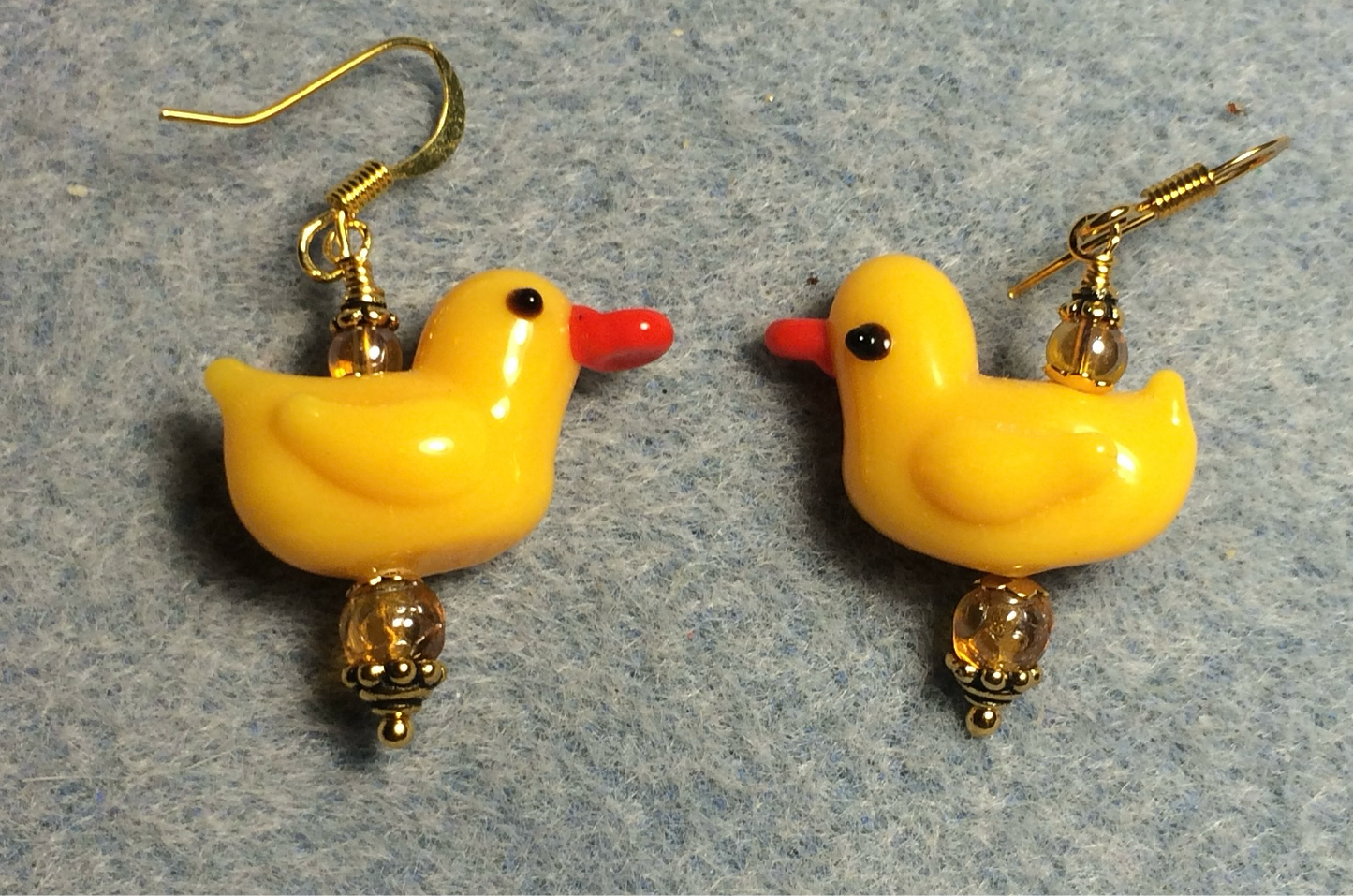 Opaque golden yellow lamp work duck bead earrings adorned with amber Czech glass beads.