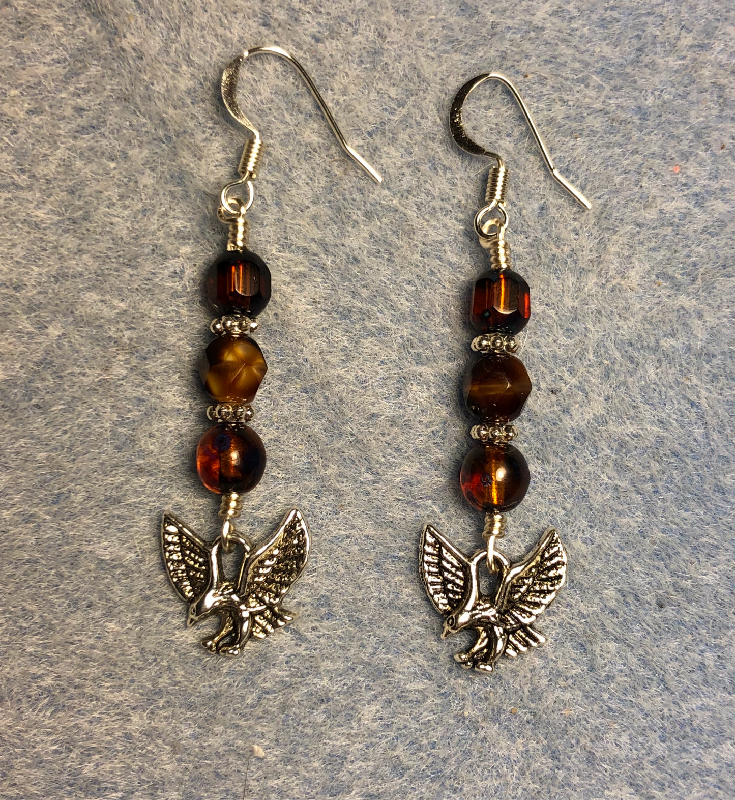 Silver hawk charm earrings adorned with brown Czech glass beads