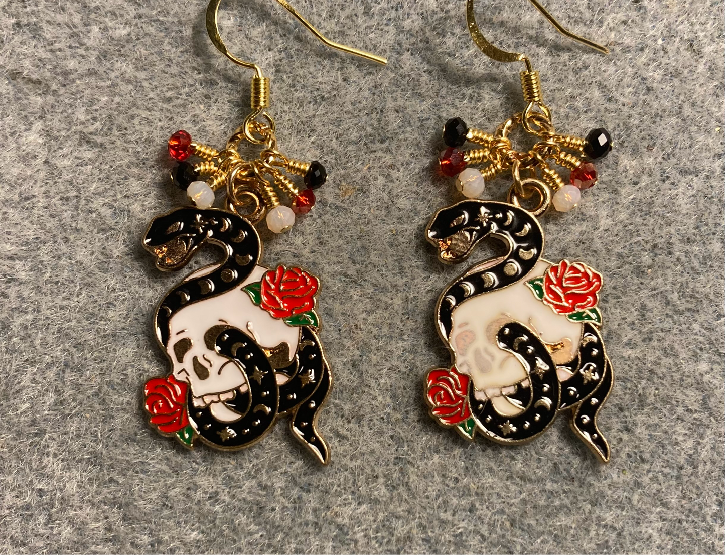 Black, white, and red enamel snake charm earrings adorned with tiny dangling black, white, and red Chinese crystal beads.