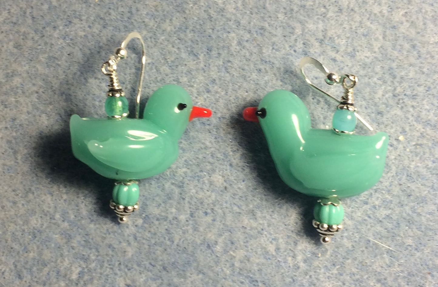 Opaque turquoise lamp work duck bead earrings adorned with turquoise Czech glass beads.