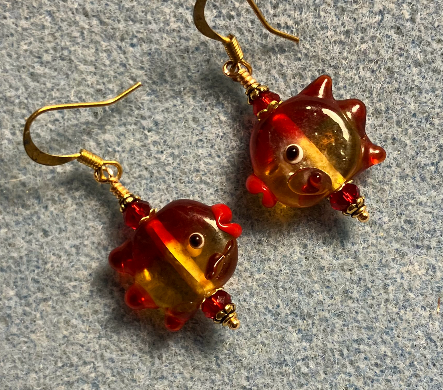 Red and amber lamp work fish bead earrings adorned with red Chinese crystal beads.