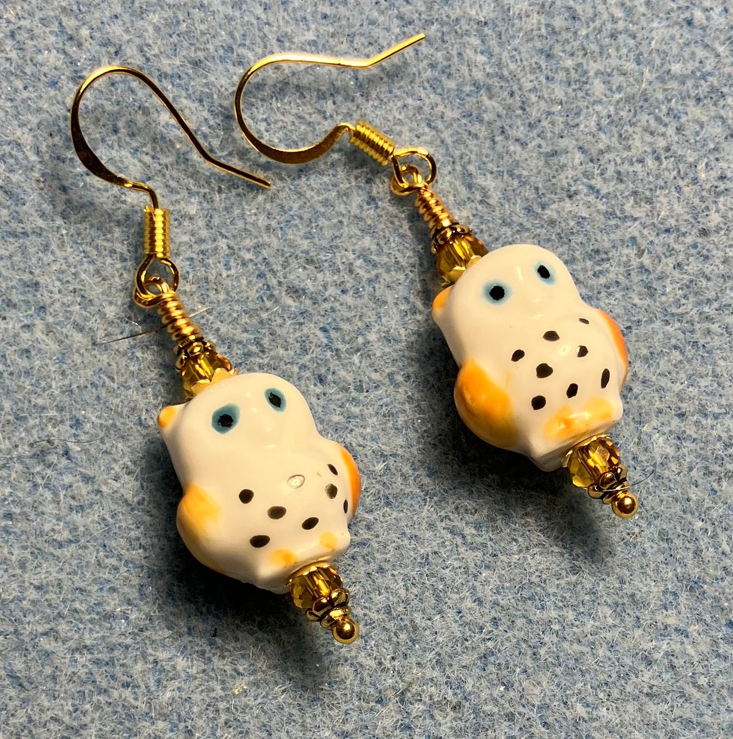 Amber, white, and blue ceramic spotted owl bead earrings adorned with amber Chinese crystal beads.