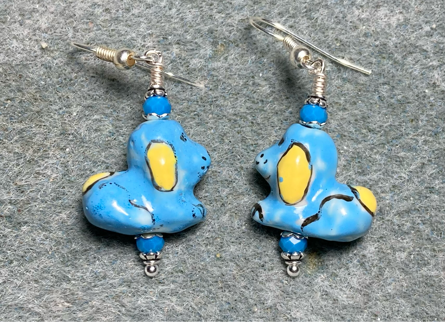 Blue and yellow ceramic puppy dog bead earrings adorned with blue Chinese crystal beads.