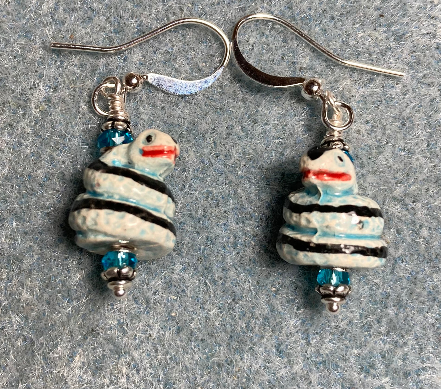 Small turquoise, black, and red ceramic coiled snake bead earrings adorned with turquoise Chinese crystal beads.