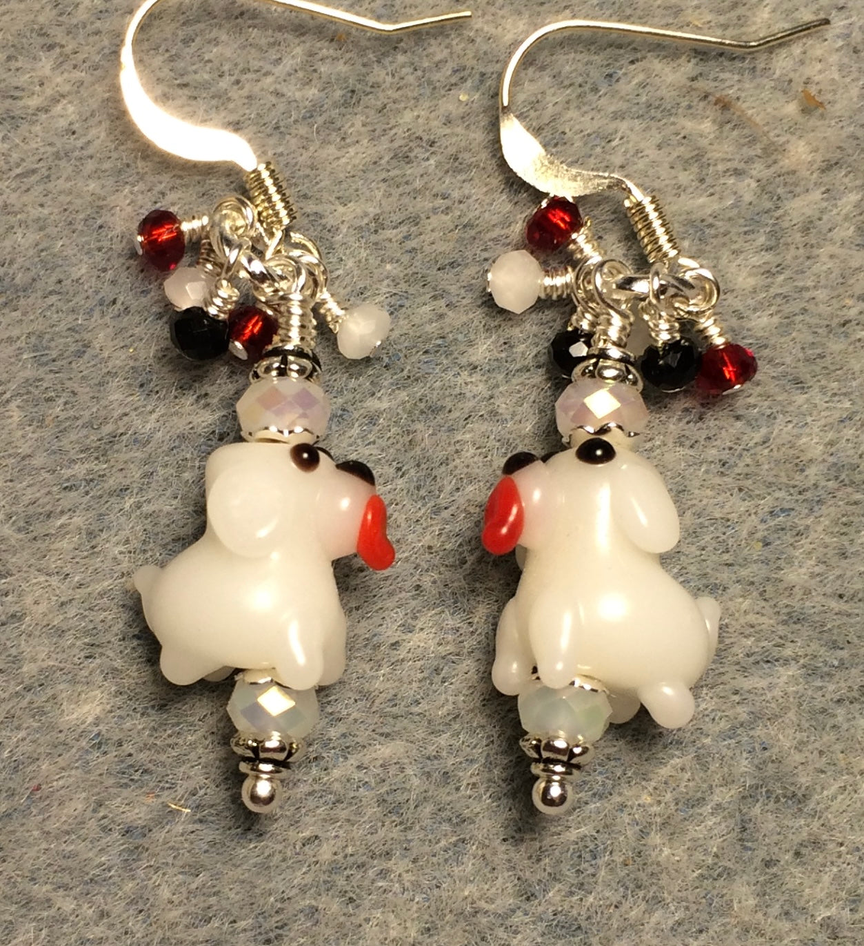 Tiny white lamp work puppy dog bead earrings adorned with white Chinese crystal beads and tiny dangling white, red, and black Chinese crystal beads.