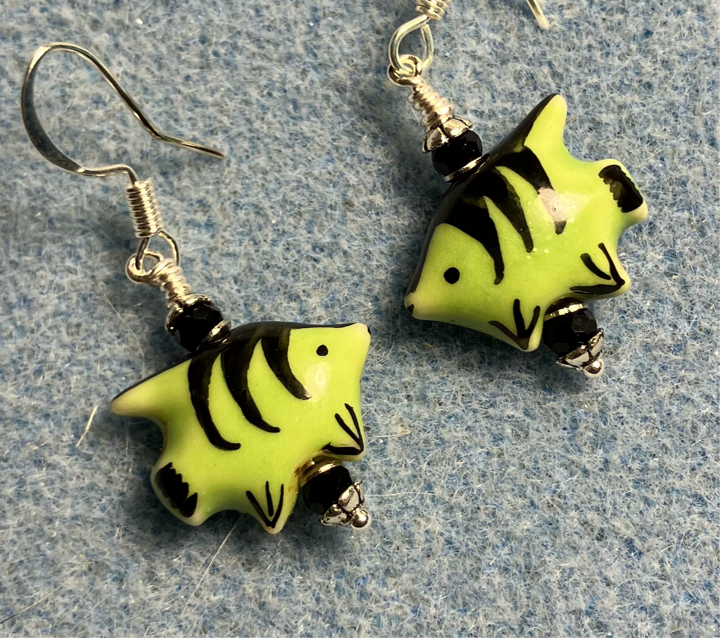 Small green and black ceramic fish bead earrings adorned with black Chinese crystal beads.