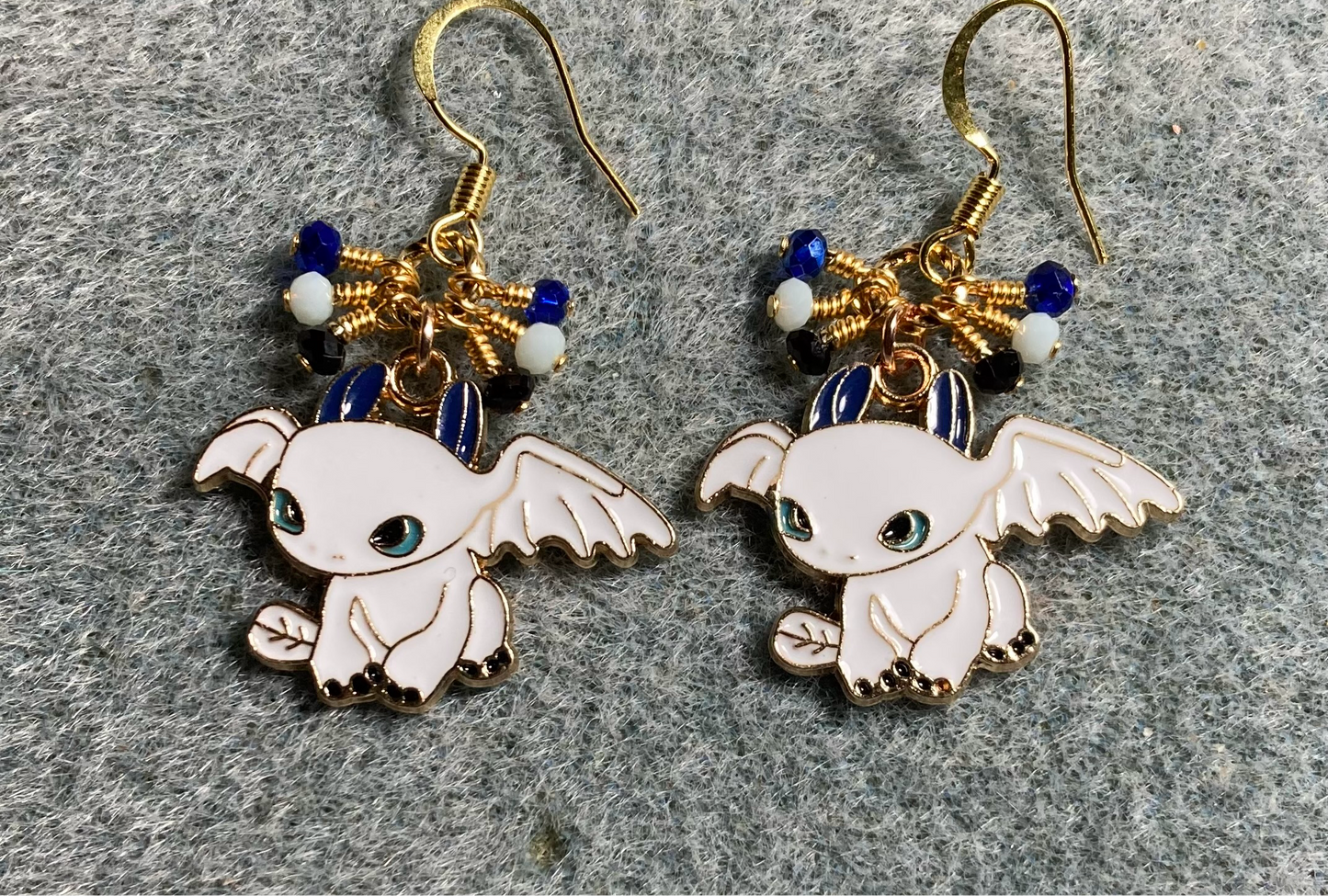 White, blue, and black enamel dragon charm earrings adorned with tiny dangling white, blue, and black Chinese crystal beads