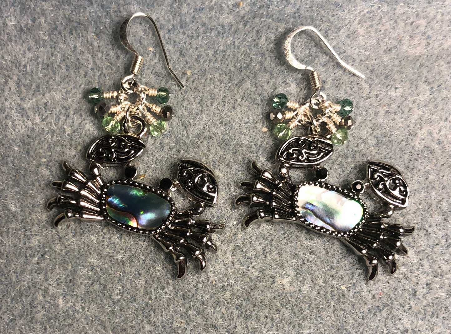 Silver and abalone crab charm earrings adorned with tiny dangling silver and green Chinese crystal beads.
