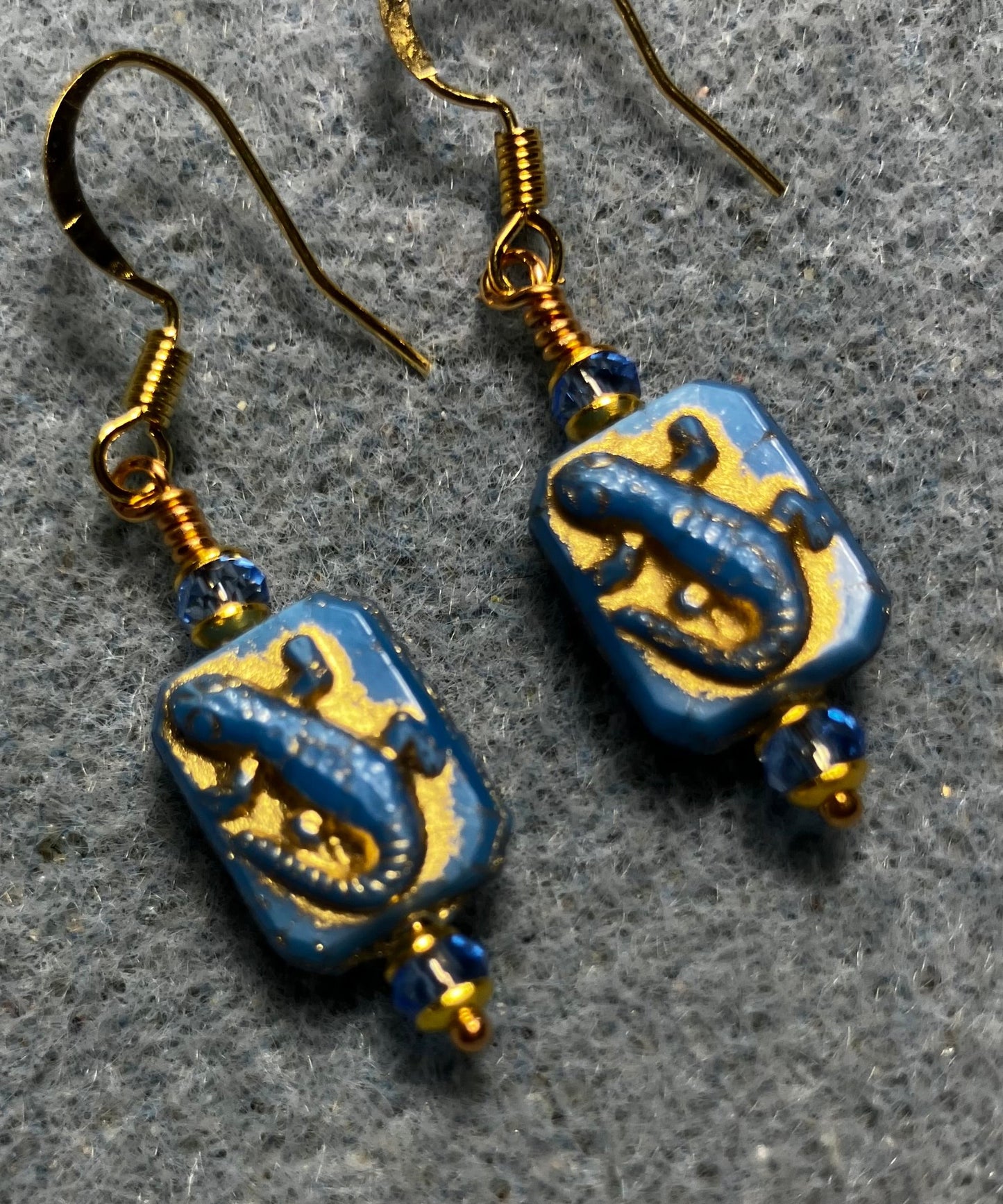 Small blue and gold Czech glass lizard bead earrings adorned with blue Chinese crystal beads.