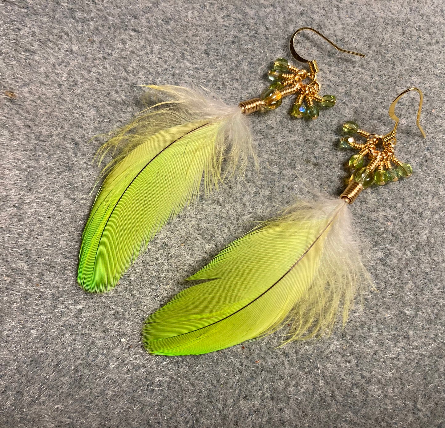 Bright lime green Amazon parrot feather earrings adorned with lime green Czech glass melon beads and small green Czech glass beads.