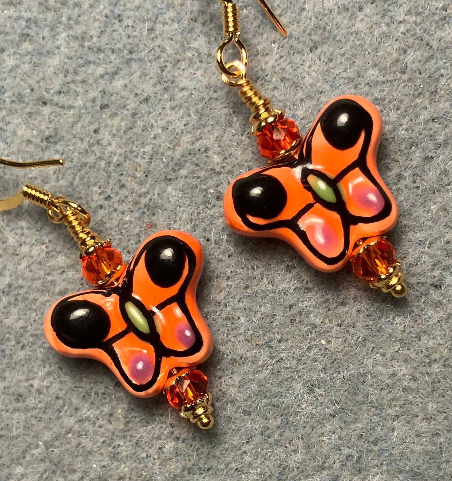 Orange and black ceramic butterfly bead earrings adorned with orange Chinese crystal beads.