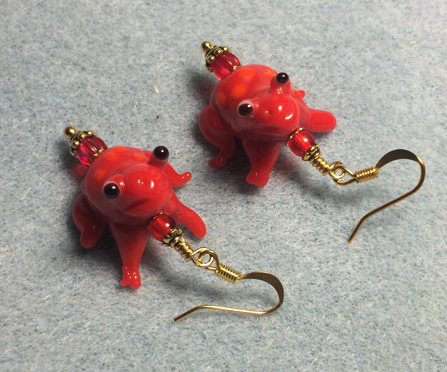 Red lamp work spotted frog bead earrings adorned with red Czech glass beads.