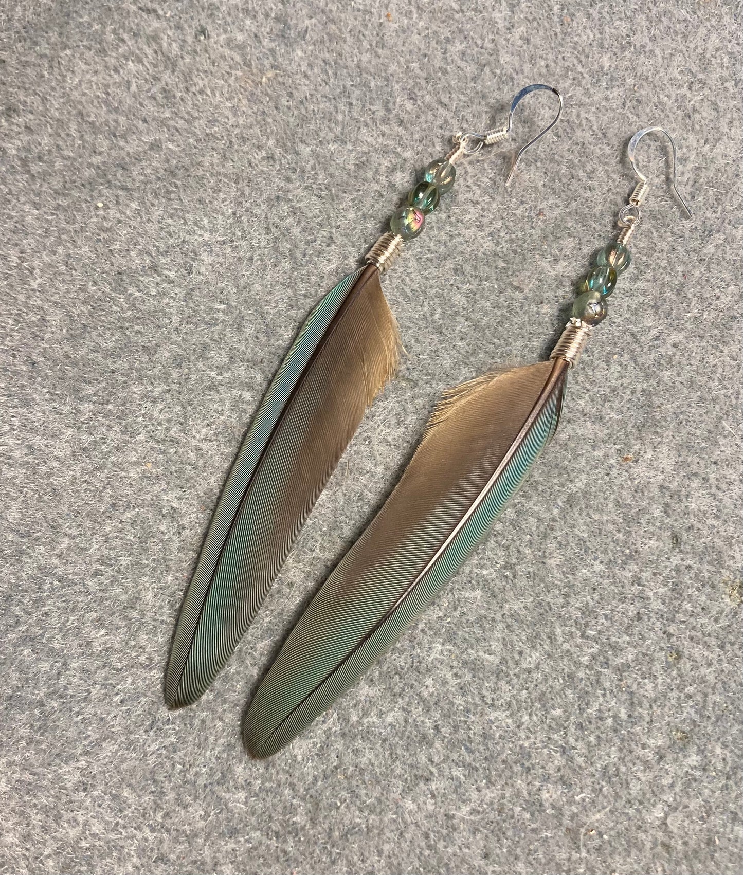 Olive green gray red-fronted macaw feather earrings adorned with olive green gray Czech glass beads.