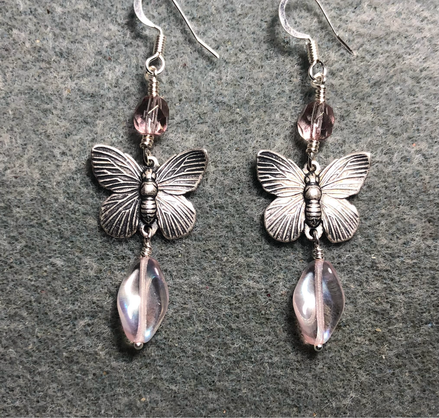 Silver butterfly charm connector earrings adorned with light pink Czech glass twist beads and light pink Czech glass beads.