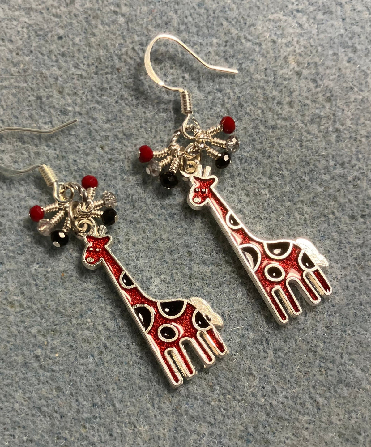 Red and black enamel spotted giraffe charm earrings adorned with tiny dangling red, clear, and black Chinese crystal beads.