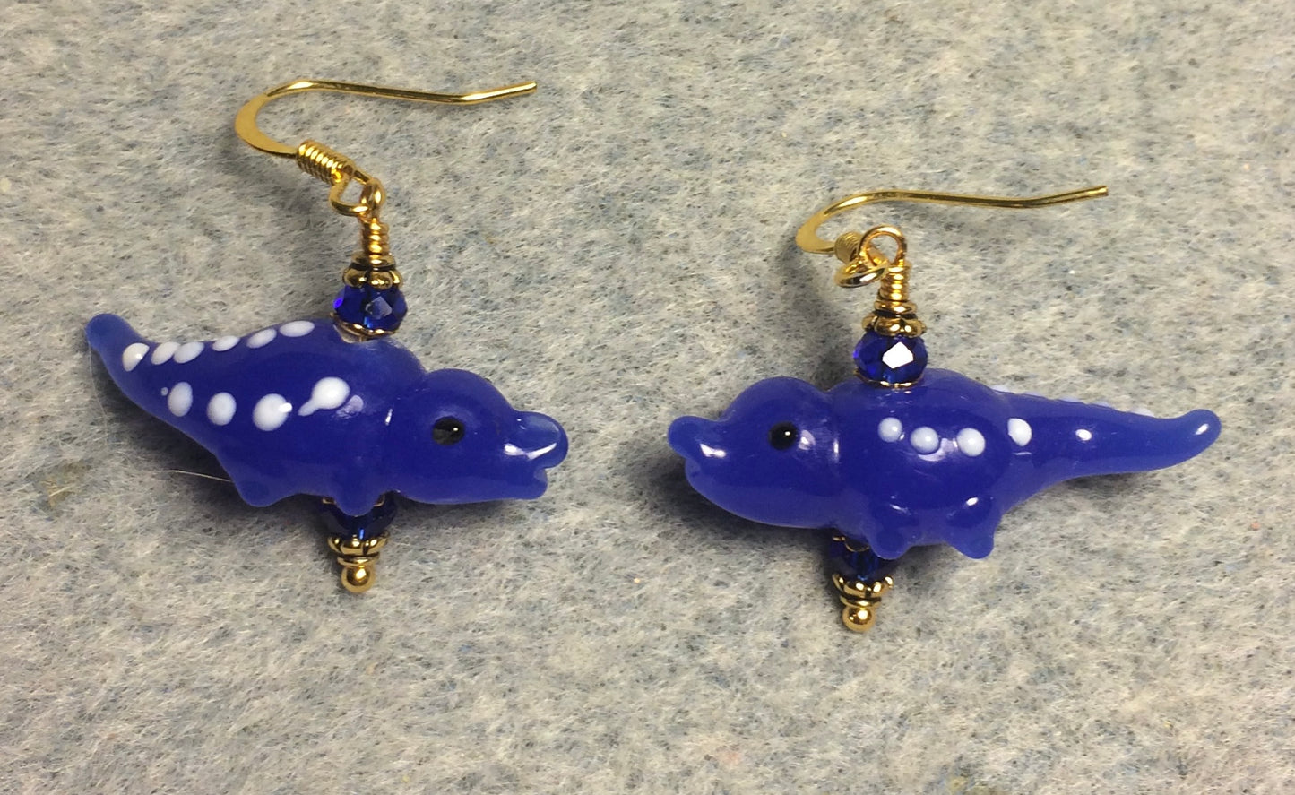 Opaque dark blue lamp work spotted alligator bead earrings adorned with dark blue Chinese crystal beads.