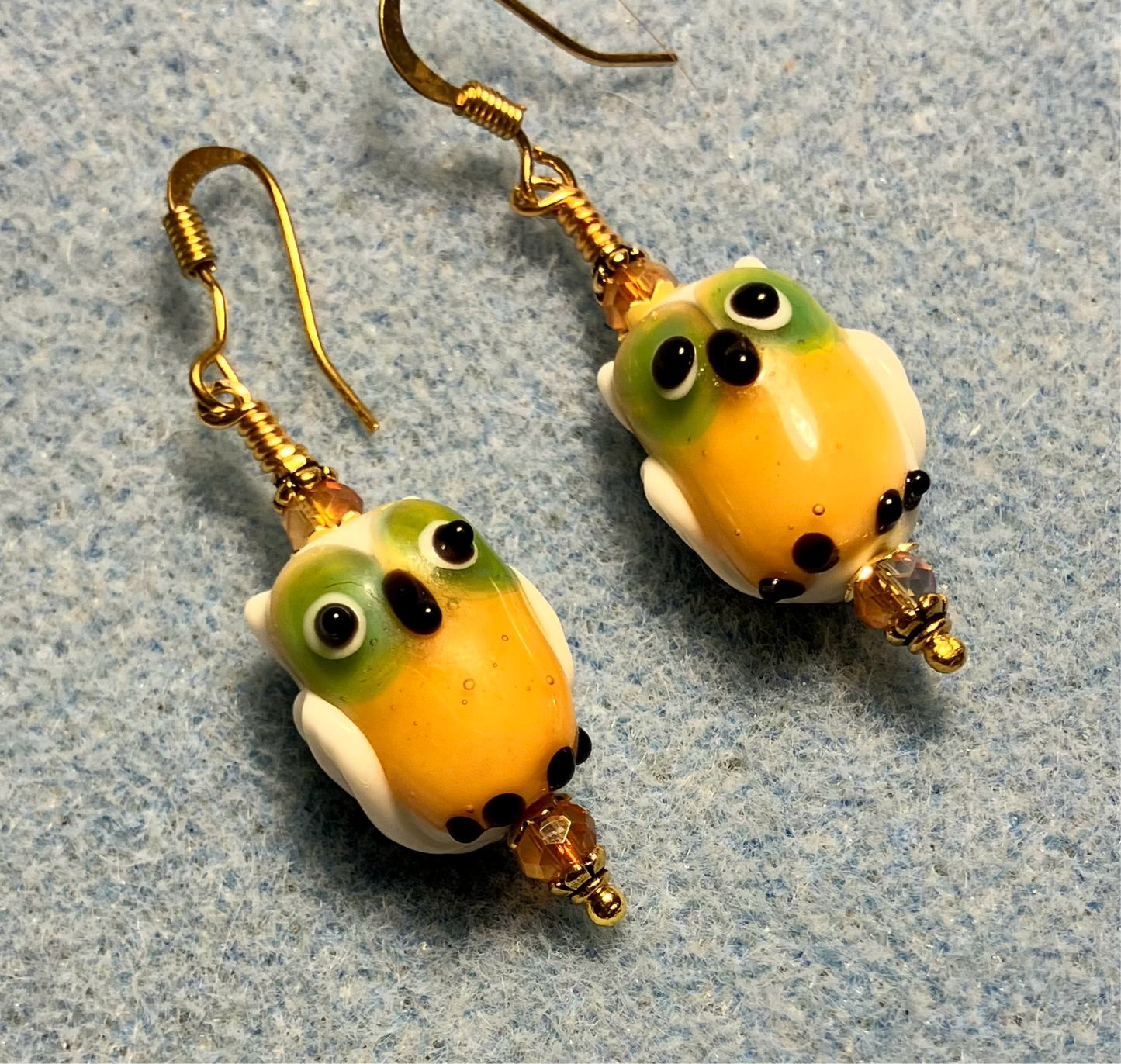 Orange lamp work owl bead earrings adorned with orange Chinese crystal beads.