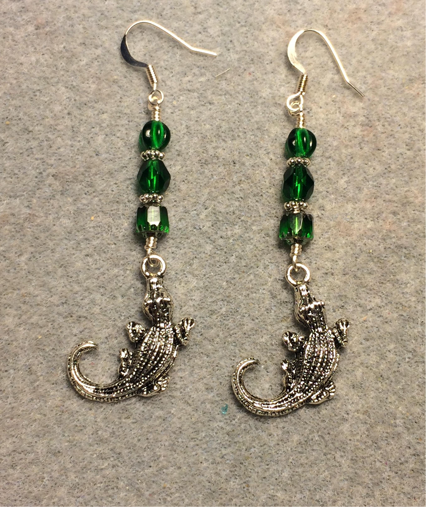 Silver alligator charm earrings adorned with emerald green Czech glass beads