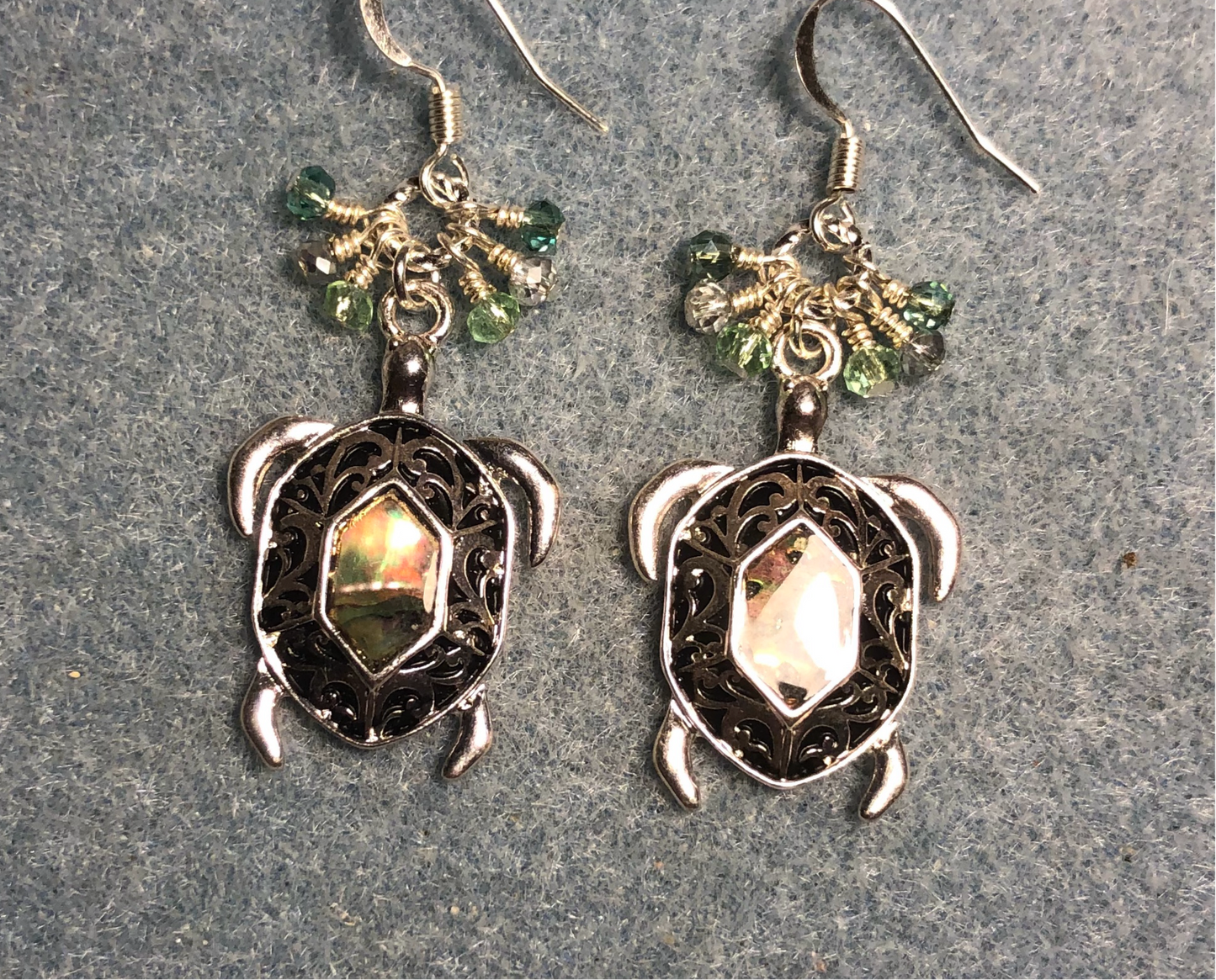 Silver and abalone turtle charm earrings adorned with small dangling light green and silver Chinese crystal beads.