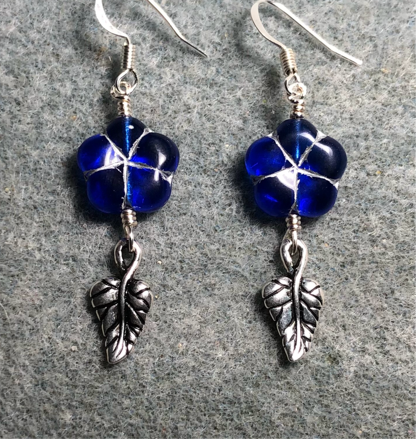 Dark blue (with silver inlay) Czech glass puffy flower bead earrings adorned with silver Tierracast leaf charms.