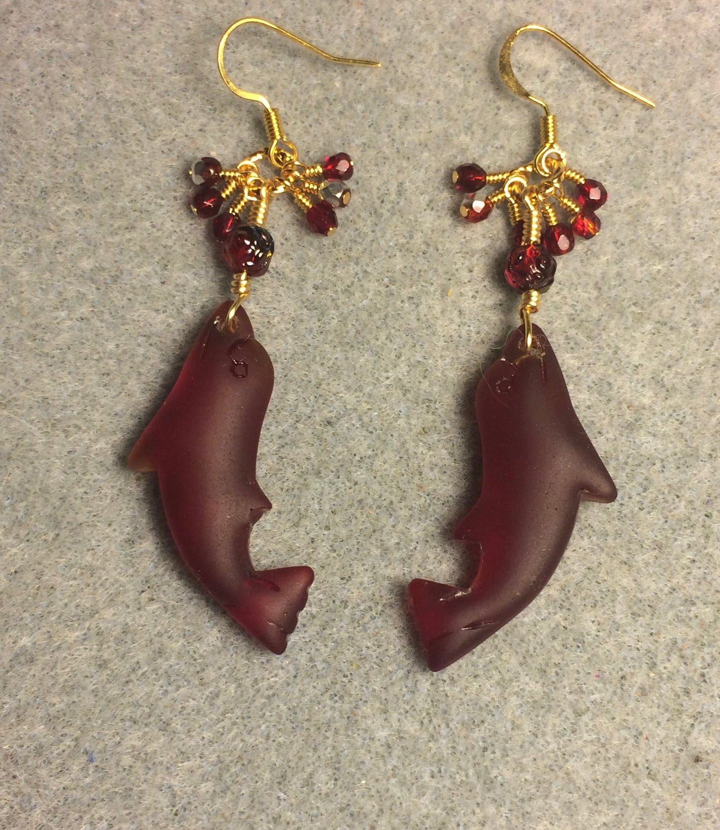 Dark red sea glass dolphin pendant bead earrings adorned with dark red Czech glass beads and tiny dangling dark red Czech glass beads.