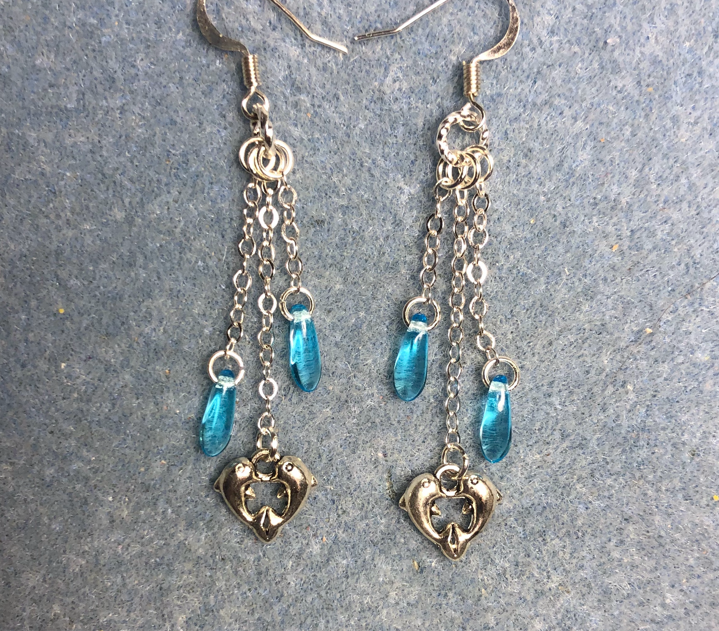 Small silver dolphin charm earrings attached to silver chain and adorned with small turquoise Czech glass dagger beads