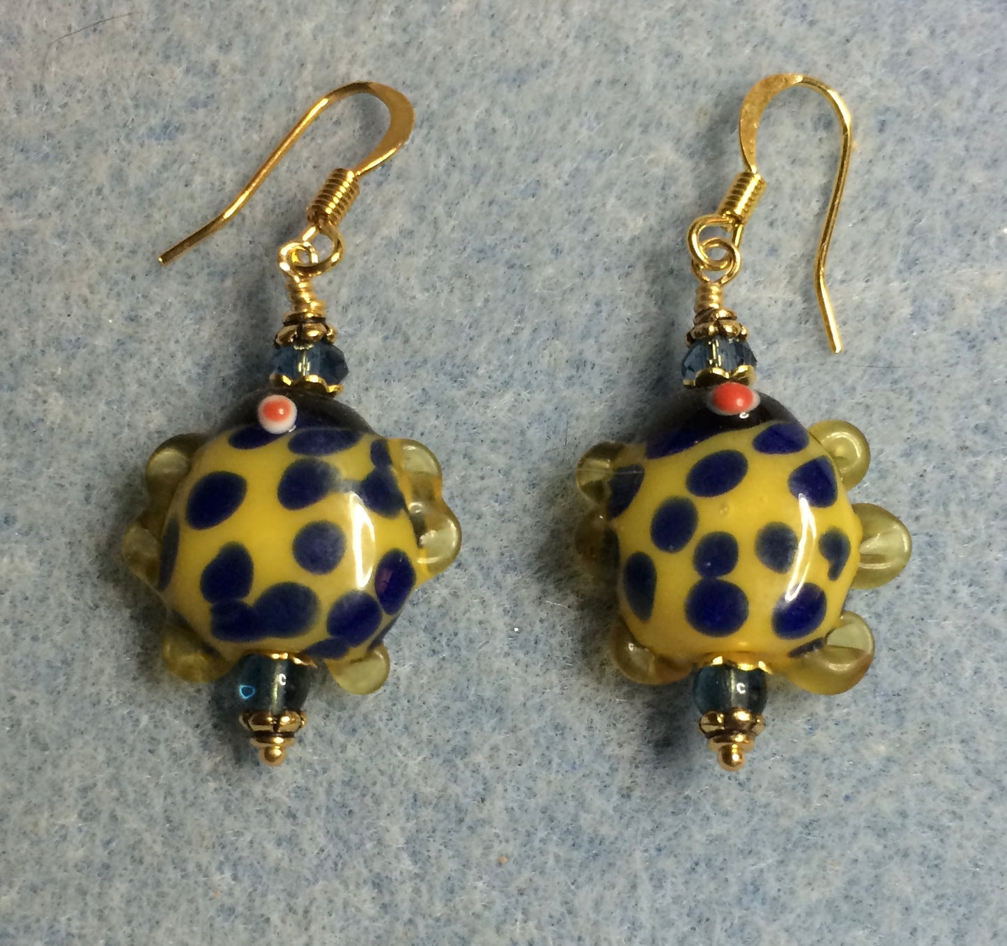 Blue and yellow lamp work polka dotted fish bead earrings adorned with blue Chinese crystal beads.