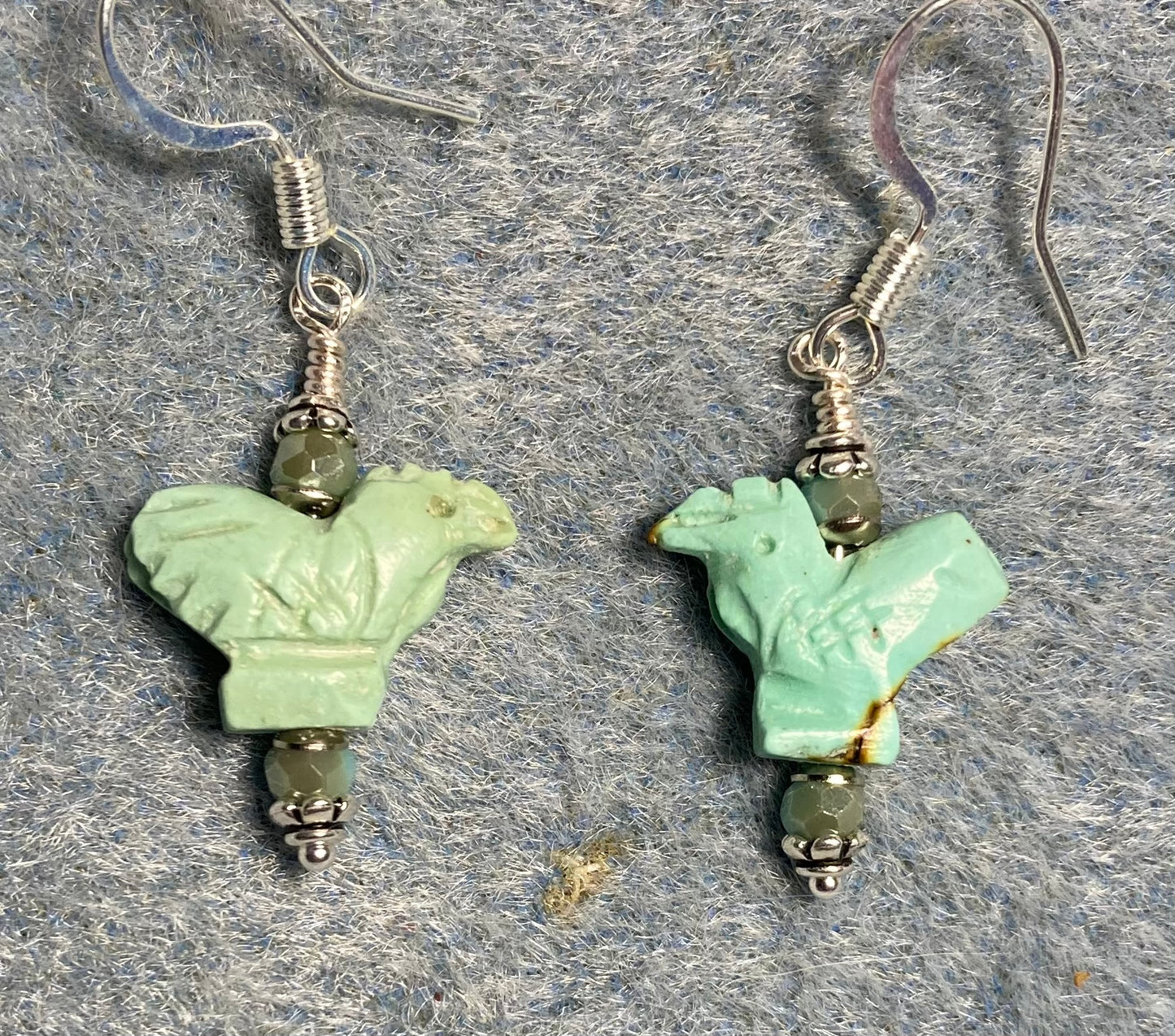 Small carved turquoise gemstone rooster bead earrings adorned with small turquoise Chinese crystal beads.