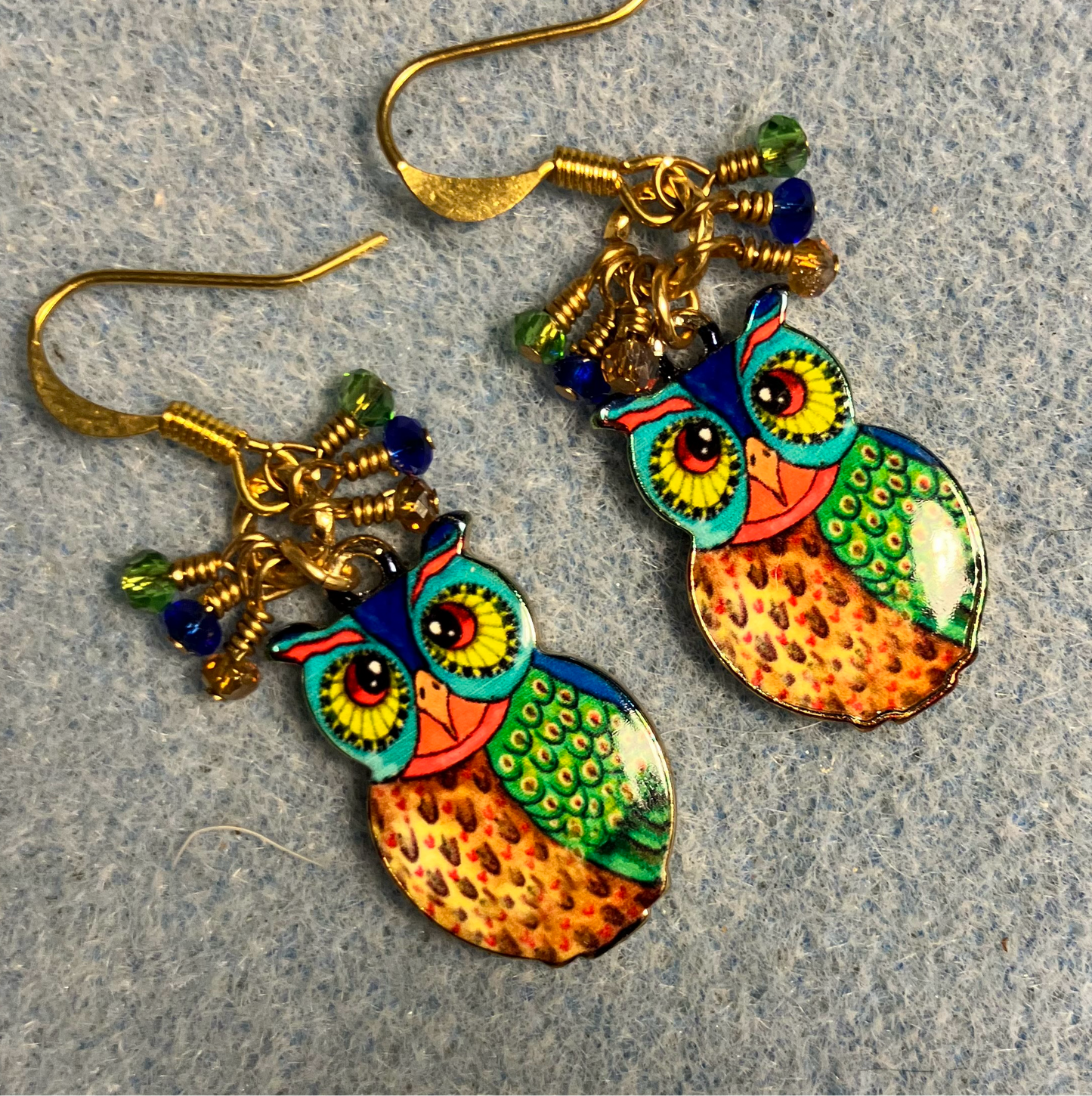Orange, green, and dark blue enamel owl charm earrings adorned with tiny dangling orange, green, and dark blue Chinese crystal beads.