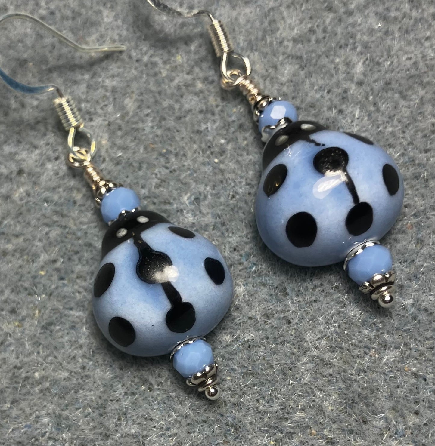 Light blue and black ceramic ladybug bead earrings adorned with light blue Chinese crystal beads.
