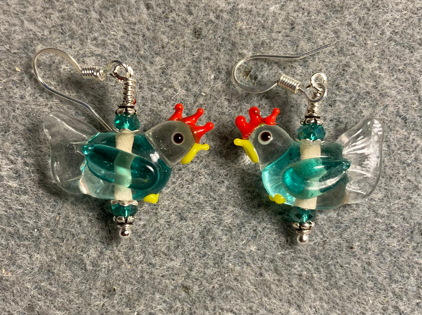 Clear and teal lamp work chicken bead earrings adorned with teal Chinese crystal beads.