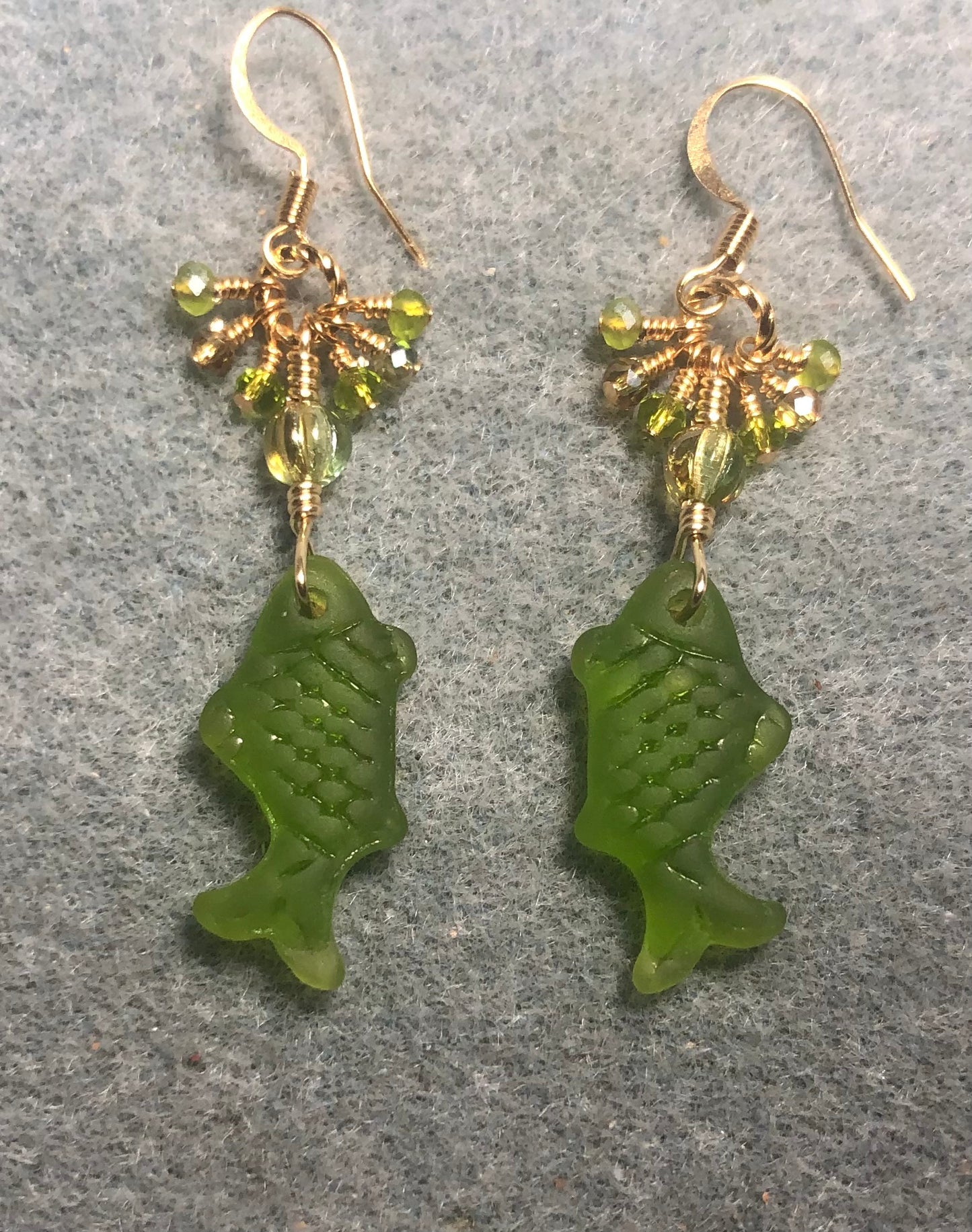 Olive green sea glass fish pendant bead earrings adorned with olive green Czech glass beads and tiny dangling olive green Chinese crystal beads.
