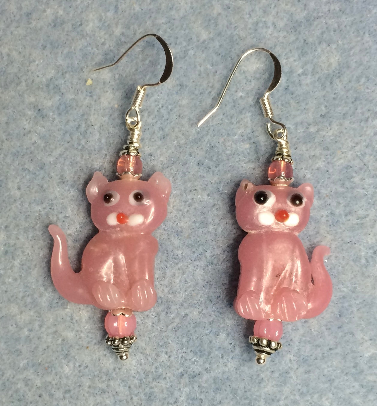 Opaque pink lamp work cat bead earrings adorned with pink Czech glass beads.