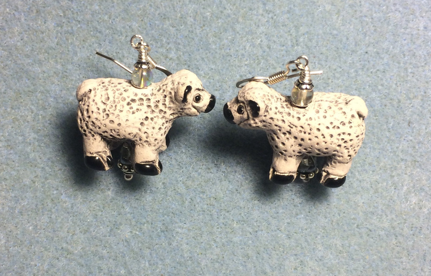 White and black ceramic sheep bead earrings adorned with clear Czech glass beads.