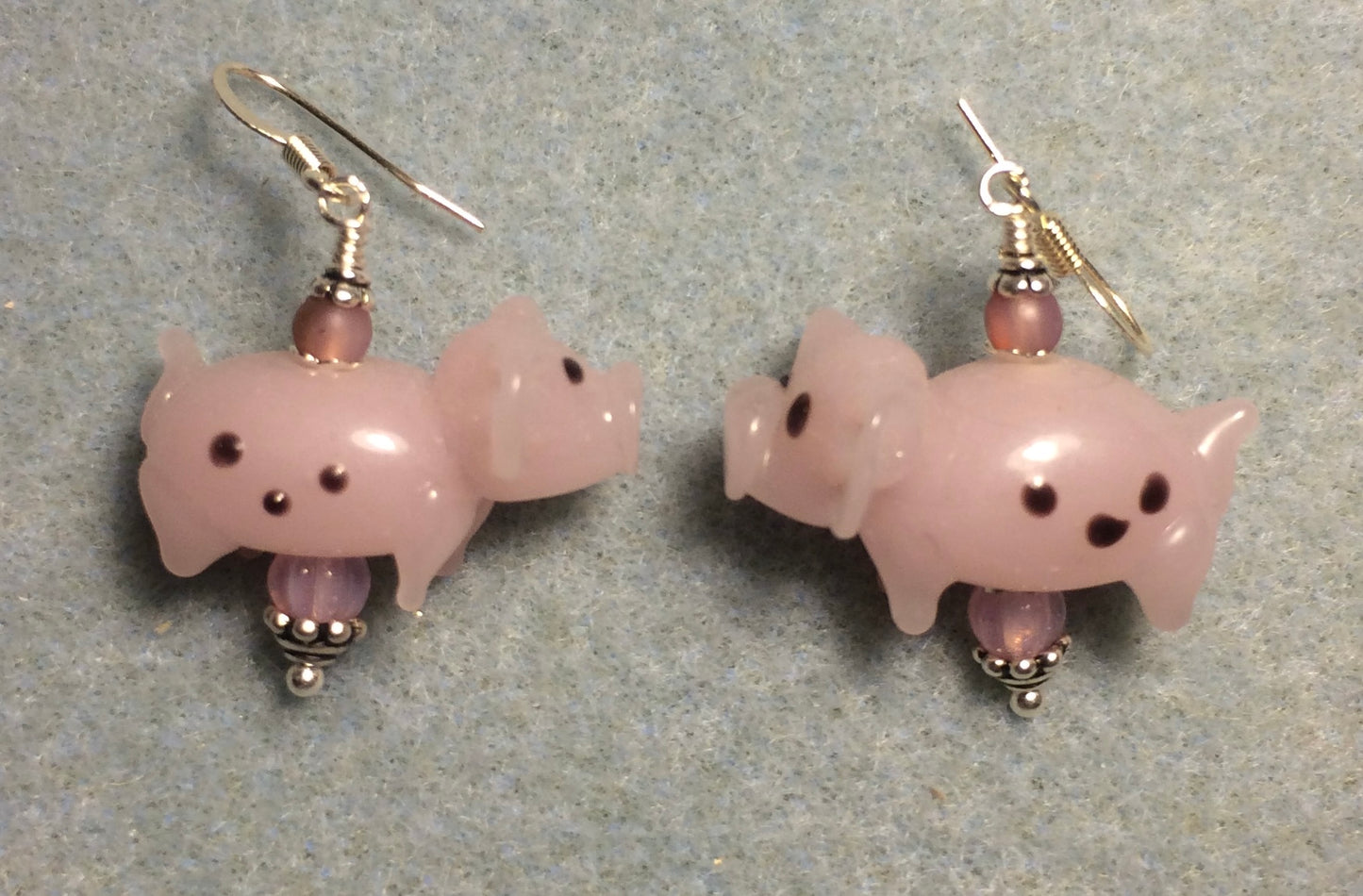 Pink lamp work spotted pig bead earrings adorned with pink Czech glass beads.