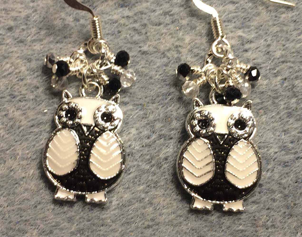 Black and white enamel owl charm earrings adorned with tiny dangling black, silver, and clear Chinese crystal beads.