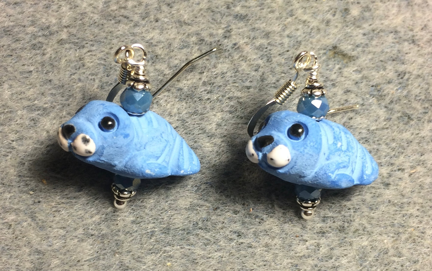 Small light blue ceramic walrus bead earrings adorned with light blue Chinese crystal beads.