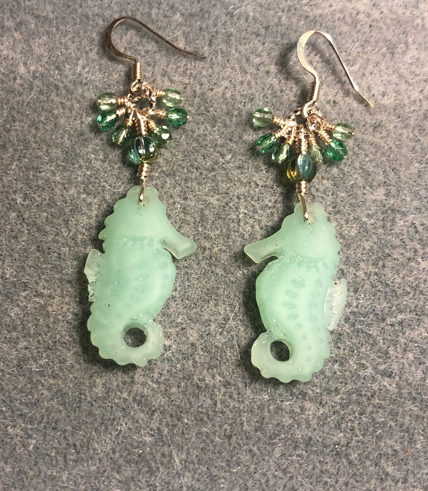 Opaque light green sea glass seahorse pendant bead earrings adorned with light green Czech glass beads and tiny dangling light green Czech glass beads.