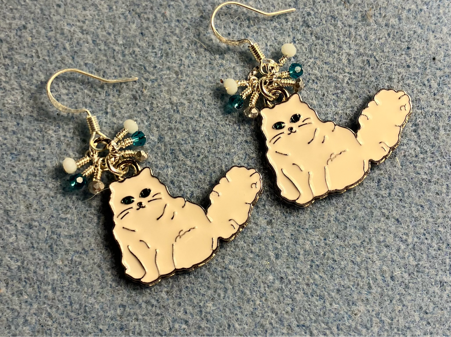 White and silver enamel Persian cat charm earrings adorned with tiny dangling white, turquoise, and silver Chinese crystal beads.