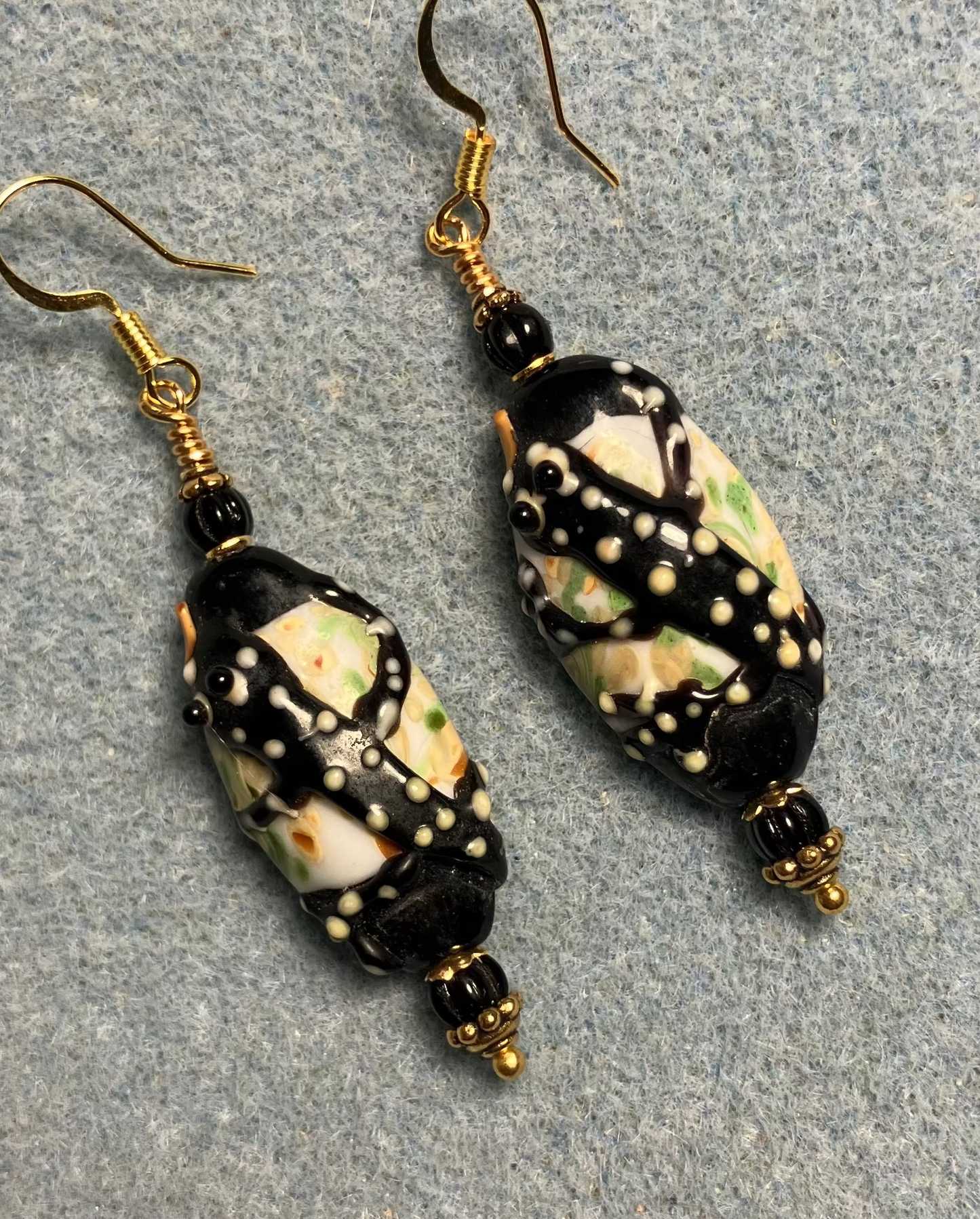 Black and yellow lamp work tiger salamander bead earrings adorned with black Czech glass beads.