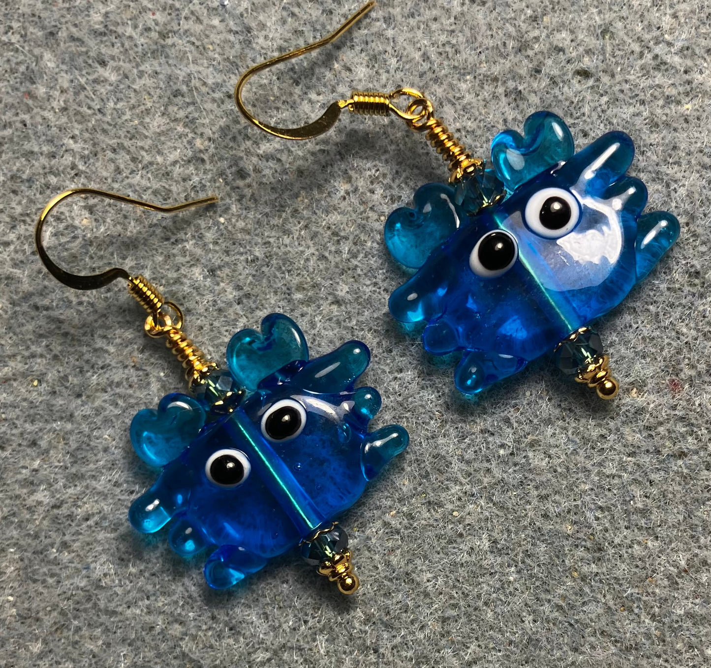Turquoise blue lamp work crab bead earrings adorned with turquoise blue Chinese crystal beads.