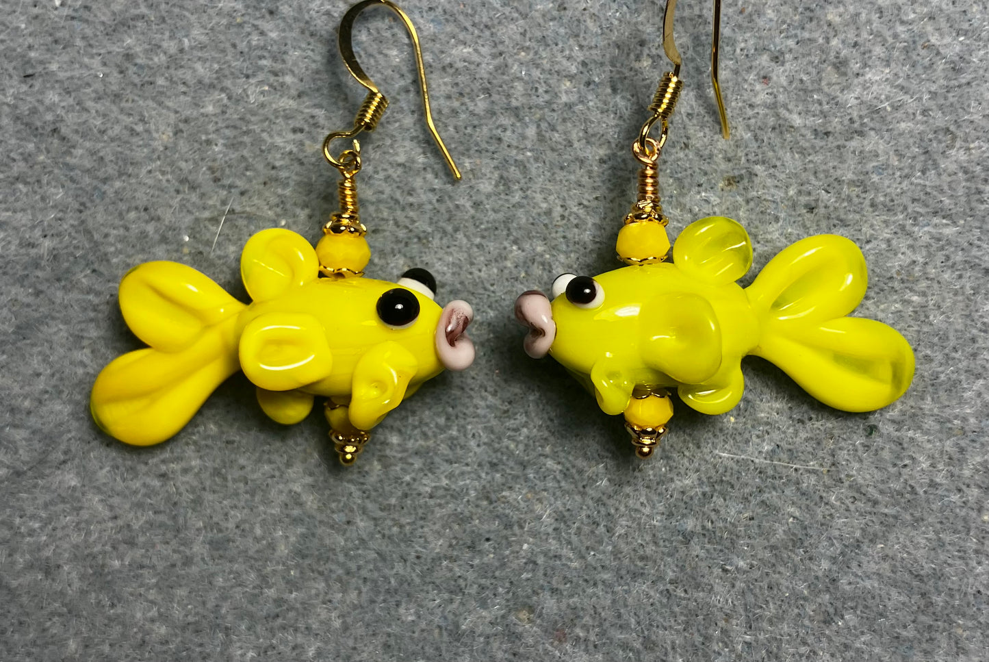 Opaque yellow lamp work fish bead earrings adorned with opaque yellow Chinese crystal beads.