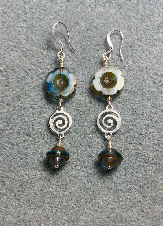 Blue striped Czech glass pansy bead earrings adorned with silver swirly connectors and blue Czech glass Saturn beads.