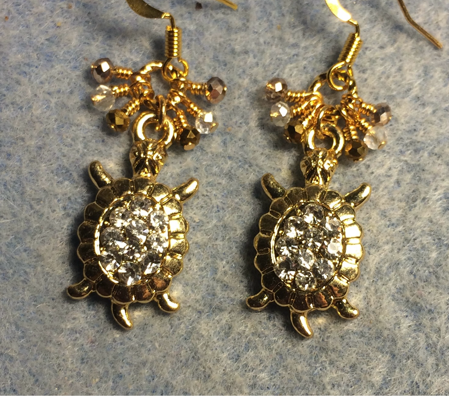 Gold and clear rhinestone turtle charm earrings adorned with tiny dangling amber, clear, and gold Chinese crystal beads.