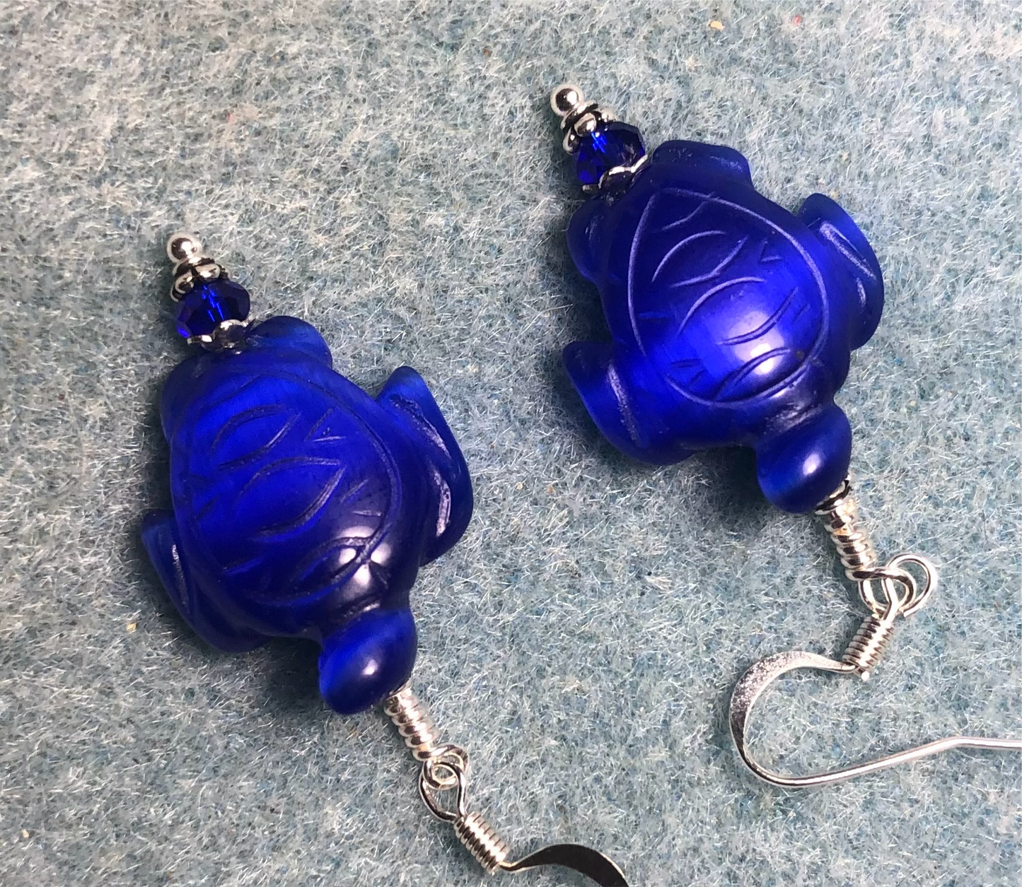 Dark blue fiber optic (cat’s eye) turtle bead earrings adorned with dark blue Chinese crystal beads.