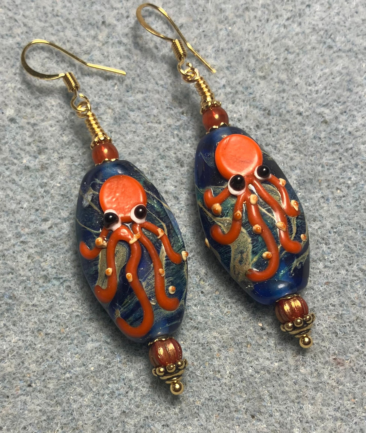 Blue and orange lamp work octopus bead earrings adorned with orange Czech glass beads.
